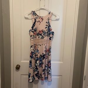 A light pink dress with different shades of blue and pink flowers.